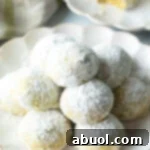 Pyramid stacks of almond and pistachio Italian wedding cookies dusted with powdered sugar.