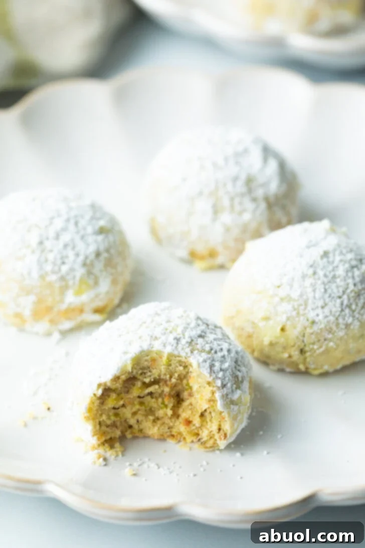 Sweet Italian Bridal Bites 5 Four Italian wedding cookies dusted with powdered sugar, with a bite taken out of the closest cookie.