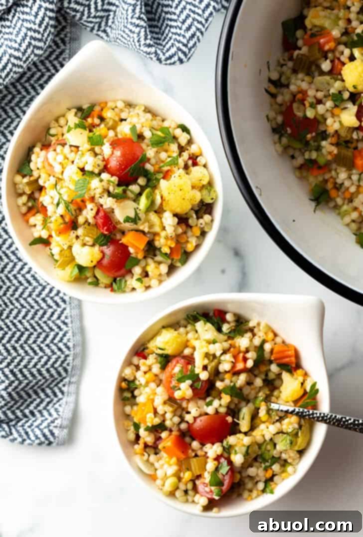 Top-down view of two beautifully presented bowls of Israeli couscous salad, ready to be enjoyed.