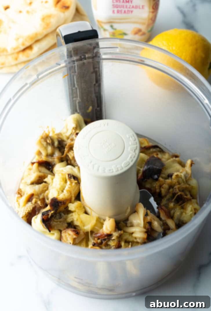 Chopped roasted garlic and eggplant in a food processor.