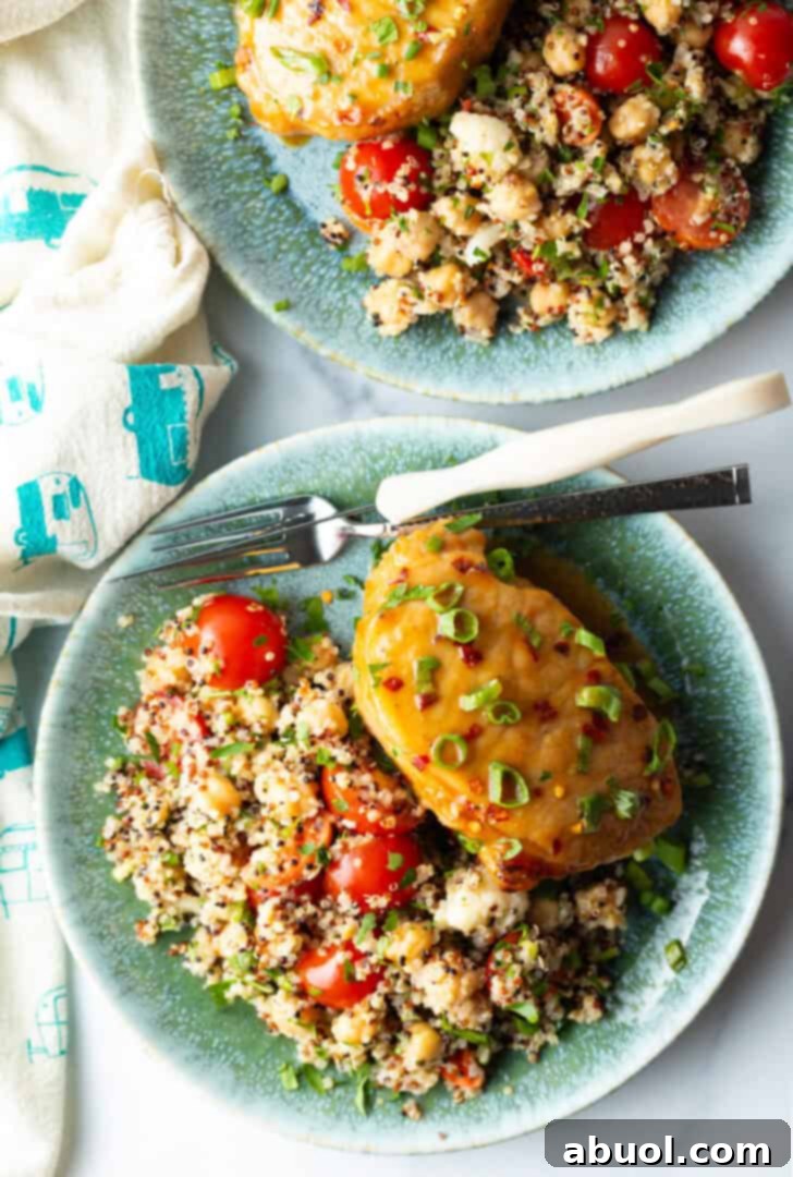 Perfectly Baked Pork Chops 4 A second view of a baked pork chop, glazed and topped with scallions, served with a side of quinoa salad.