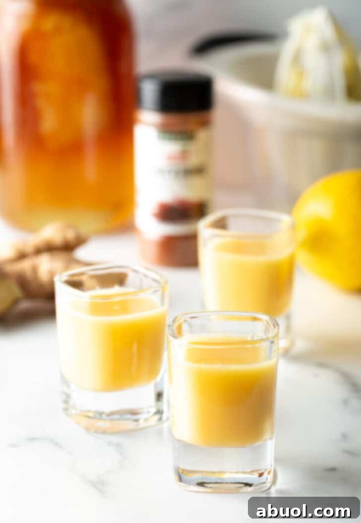 Three shot glasses brimming with invigorating ginger shots, artfully arranged on a clean surface.