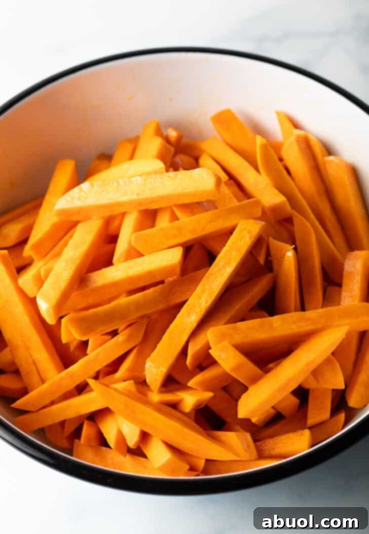 Slices of raw sweet potato in a large white bowl.