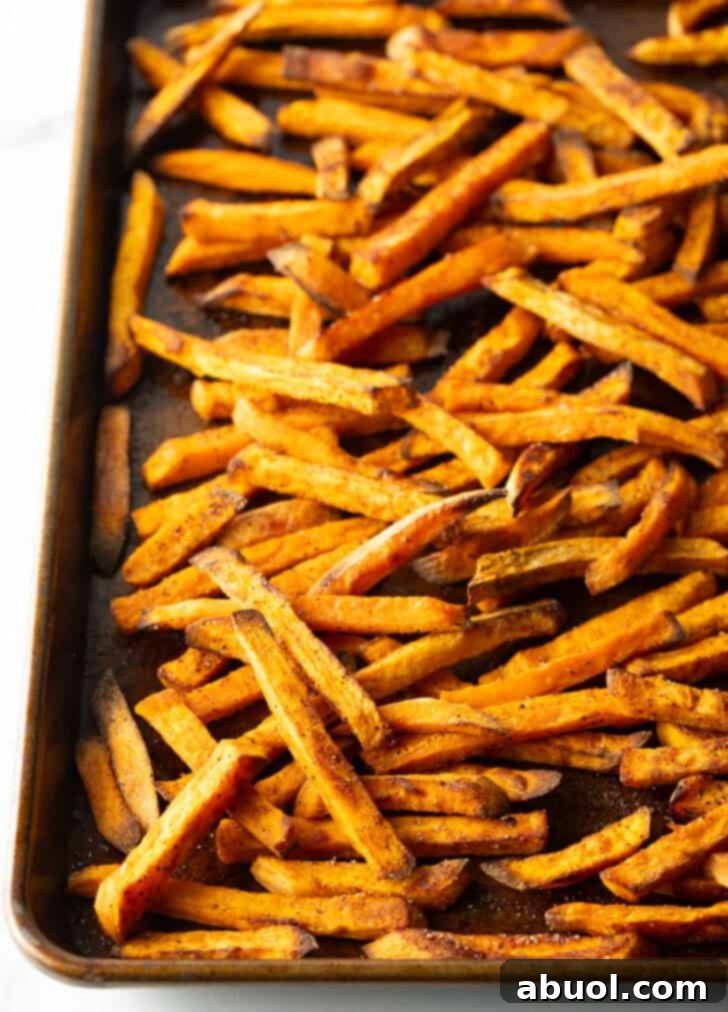 Baking sheet covered with baked sweet potato fries.