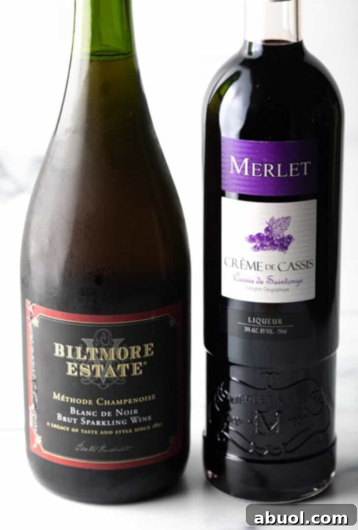 A bottle of champagne and bottle of creme de cassis.