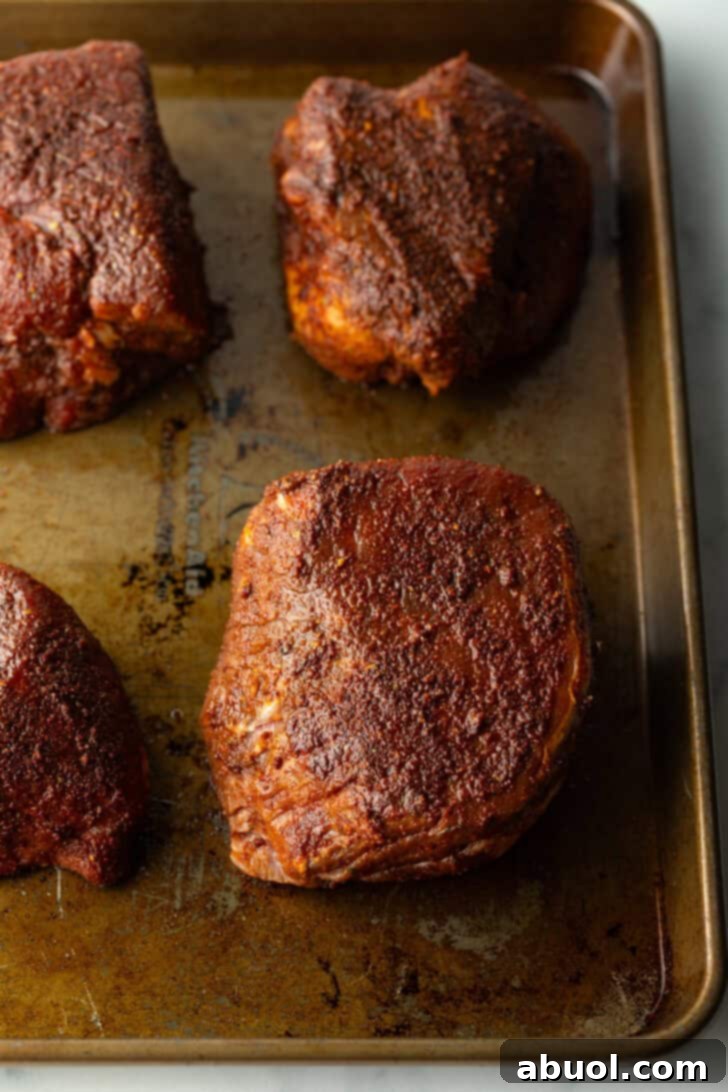 Four baked filets on a baking sheet.