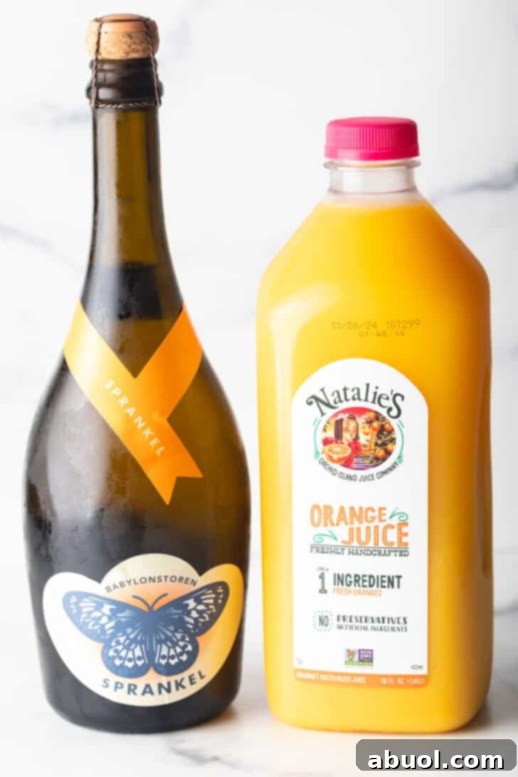 A bottle of champagne next to a bottle of orange juice.