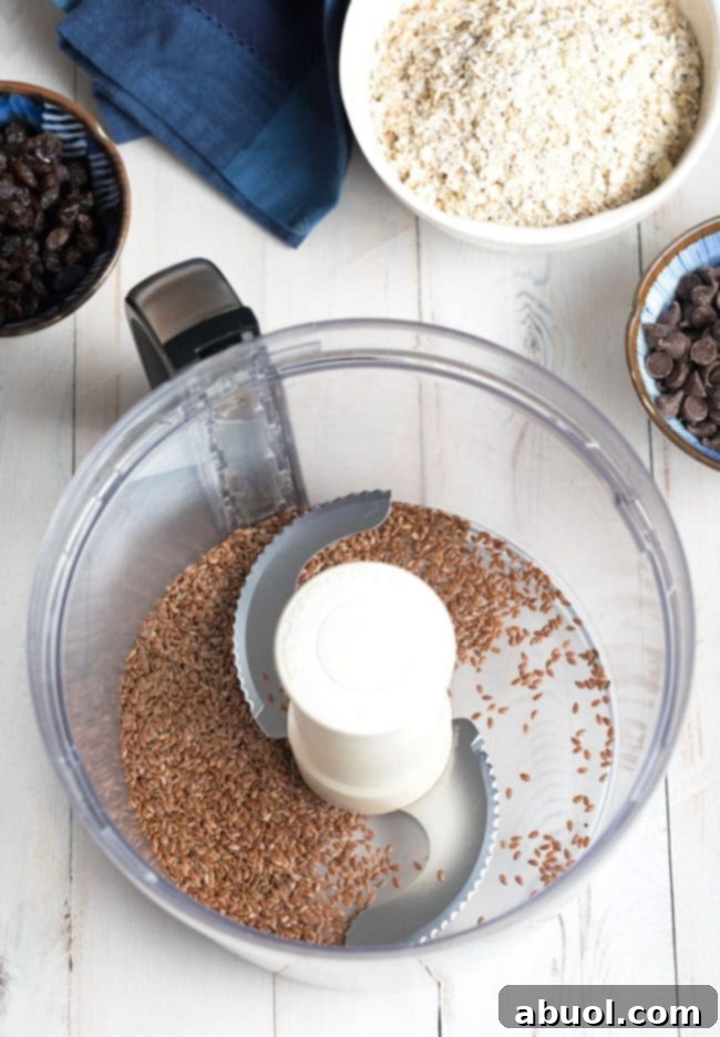 Close-up shot of flax seeds being processed in a food processor, highlighting the initial step of preparing ingredients for the energy balls.