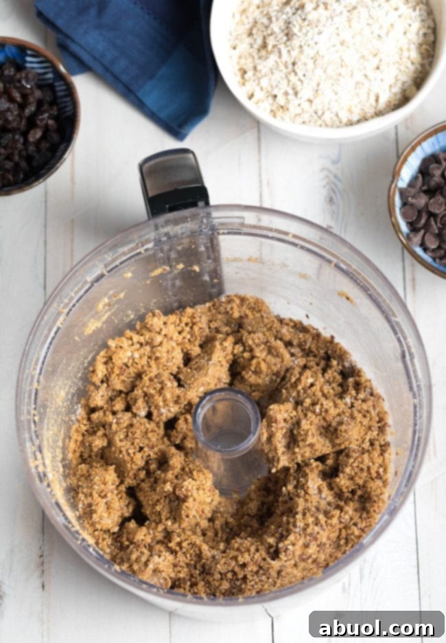 The food processor bowl filled with finely crumbled energy ball dough, showcasing the perfectly blended texture before final additions.