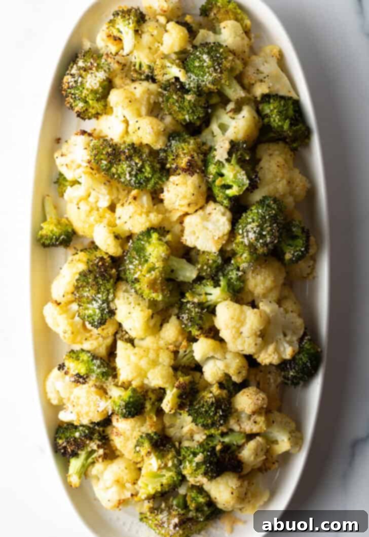 Another perspective of the white oval platter, brimming with tender and crispy roasted broccoli and cauliflower florets, ready to be served.