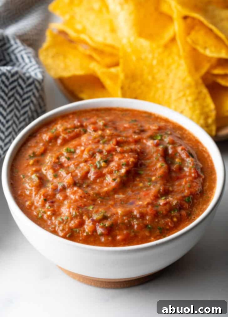 White bowl of red roasted tomato salsa.