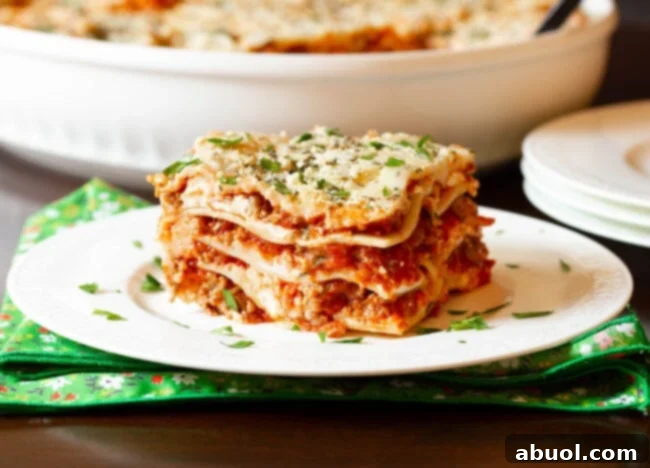 Easy sausage lasagna recipe with cream cheese cut into squares on a white plate, ready to serve.