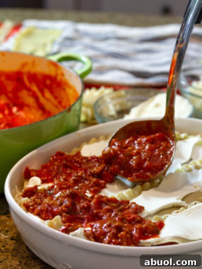 Adding rich meat sauce to cream cheese lasagna layers