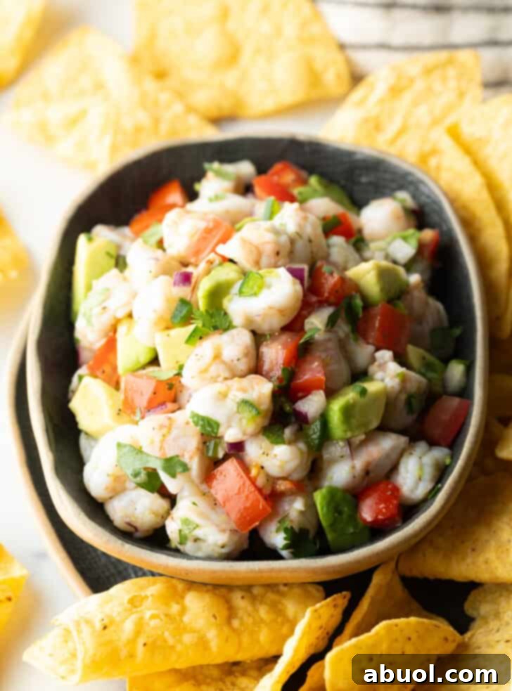 How to Make Shrimp Ceviche - Top down view yellow bowl with shrimp ceviche. The bowl is surrounded by tortilla chips.