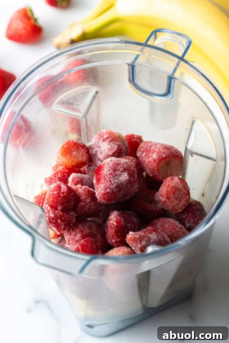 Frozen strawberries in a blender jar.