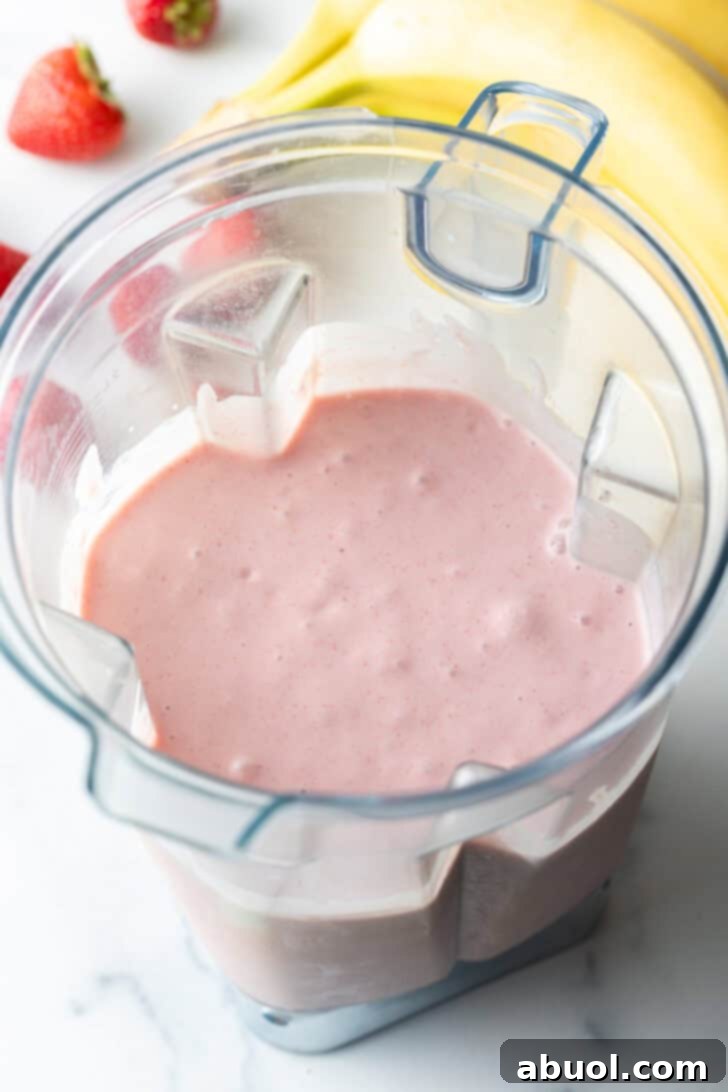 Pink smoothie in a blender jar.