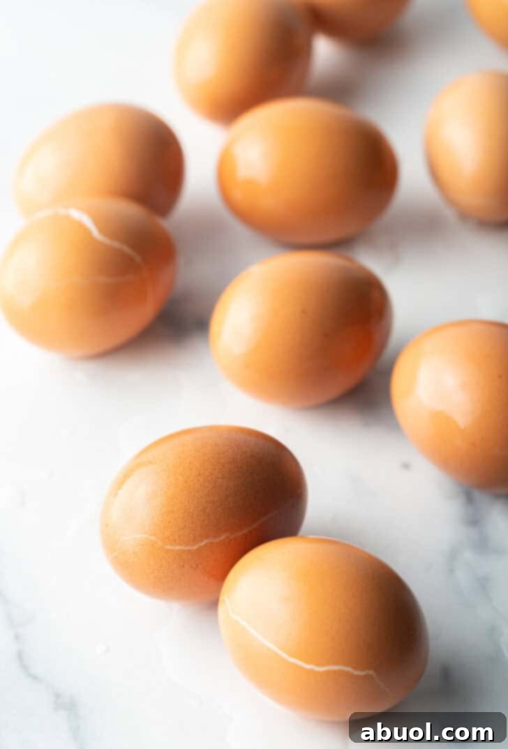 A beautifully presented arrangement of a dozen perfectly hard-boiled brown eggs on a pristine white marble background, showcasing their uniform shape and readiness.