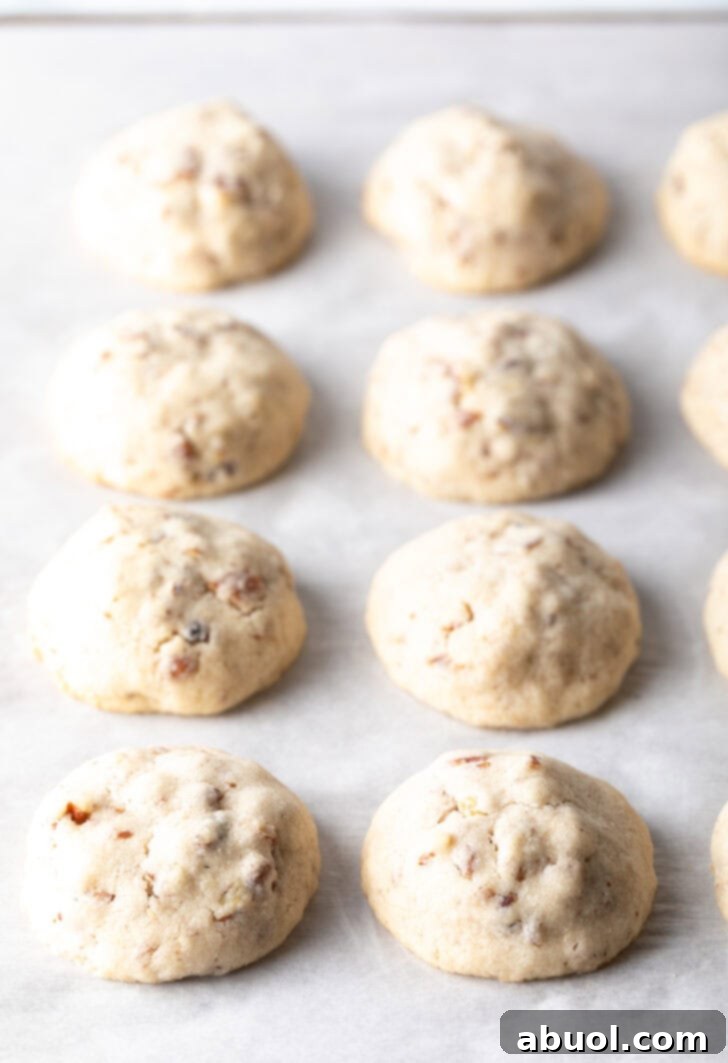 8 baked Russian tea cake cookies on parchment.