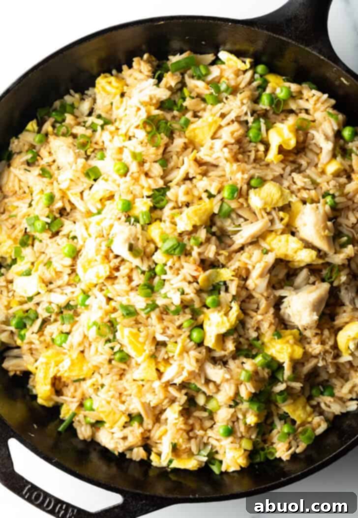 Fragrant Thai Crab Fried Rice 11 Black cast iron skillet with crab fried rice with chunks of crab meat and peas.