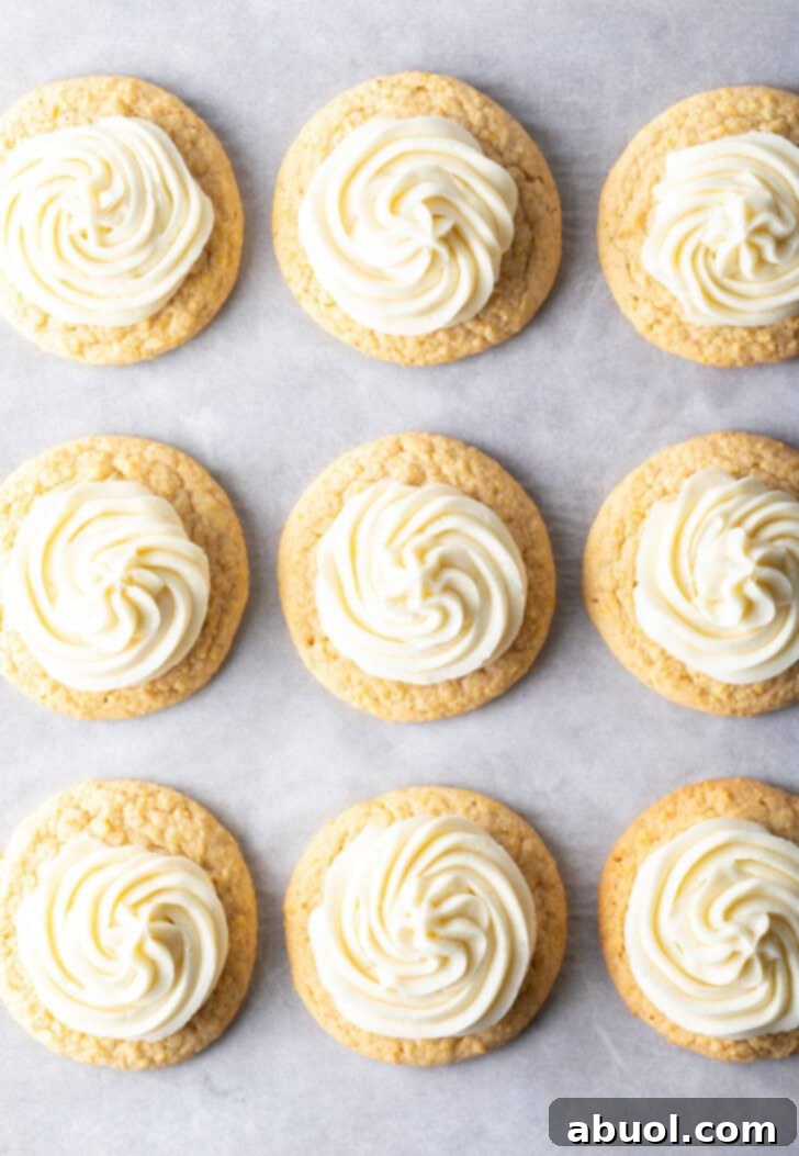 Top down view 9 frosted honey butter cookies on a baking sheet.
