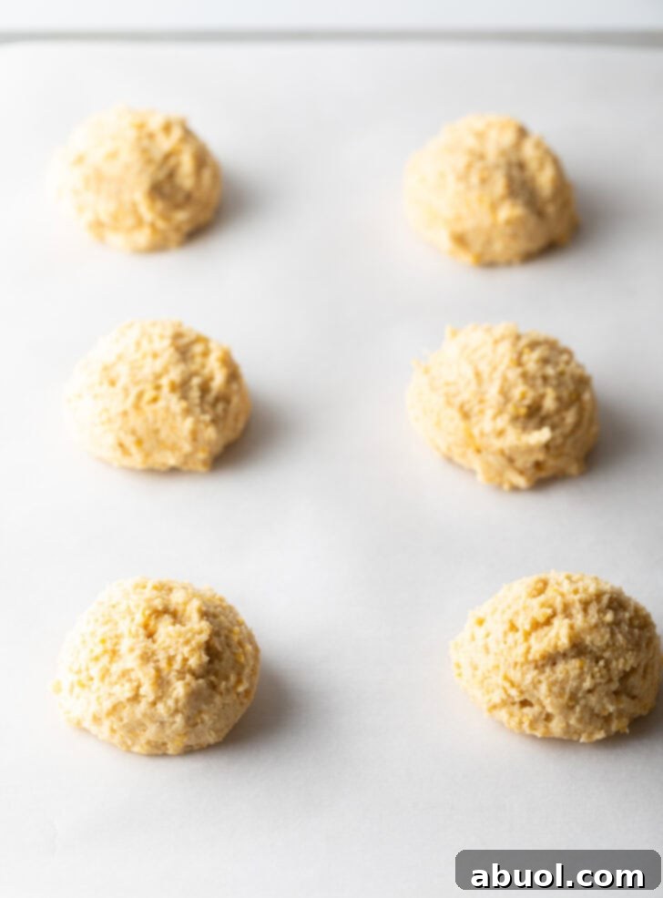 6 balls of cookie dough on a baking sheet.