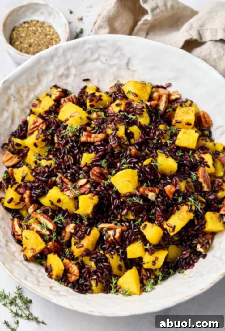A large bowl of vibrant Forbidden Black Rice with Acorn Squash and Pecans, ready to serve.