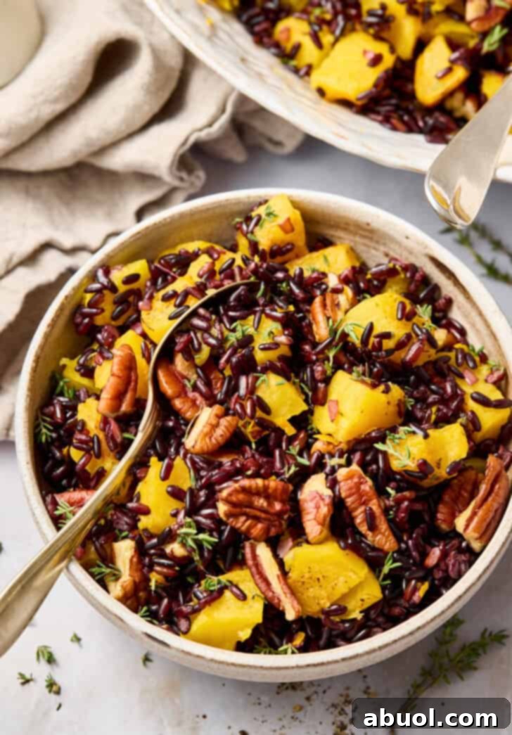 Close-up of Forbidden Rice in a small serving bowl, garnished with pecans and roasted acorn squash.