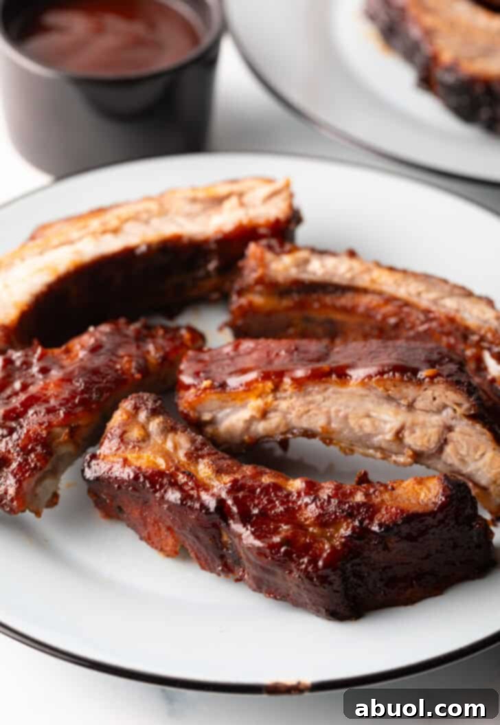 Five succulent air fried baby back ribs, beautifully plated on a white dish, ready to be devoured.