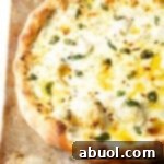 Baked whole white pizza on a baking sheet.