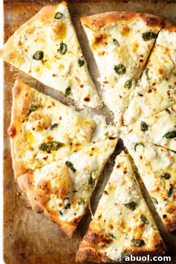 Top down view pizza with white sauce cut into 8 slices.