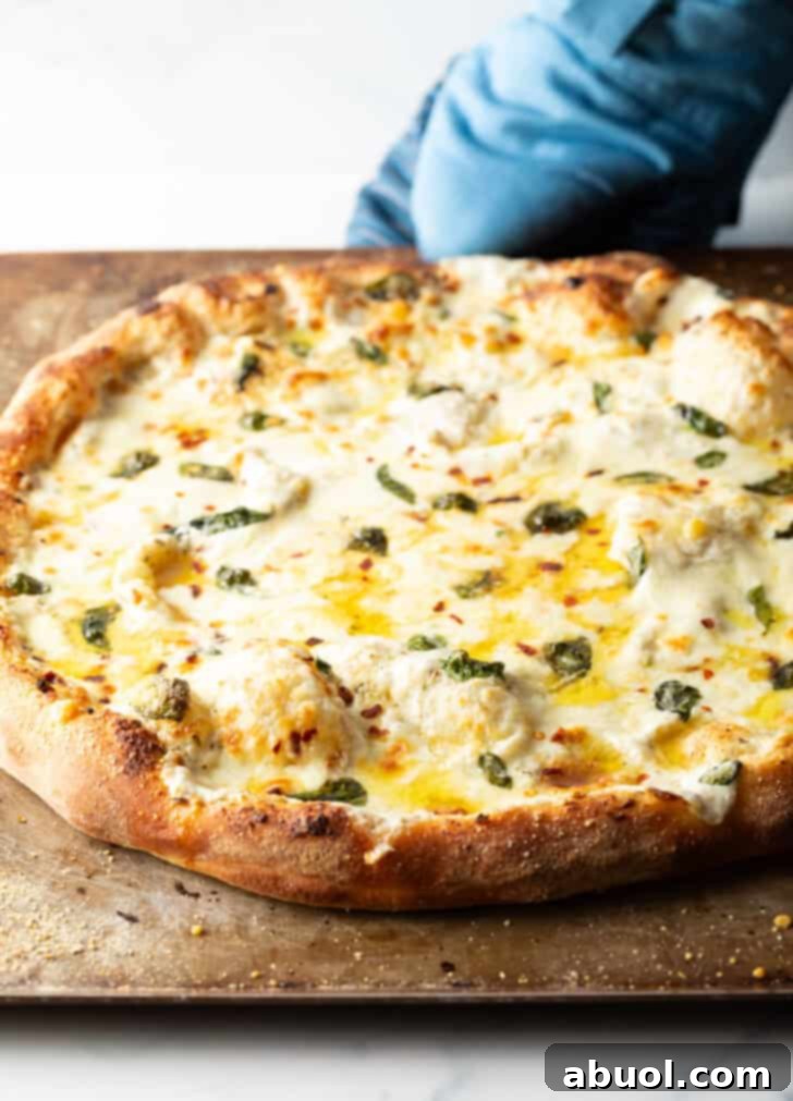 Baked whole white pizza on a baking sheet.