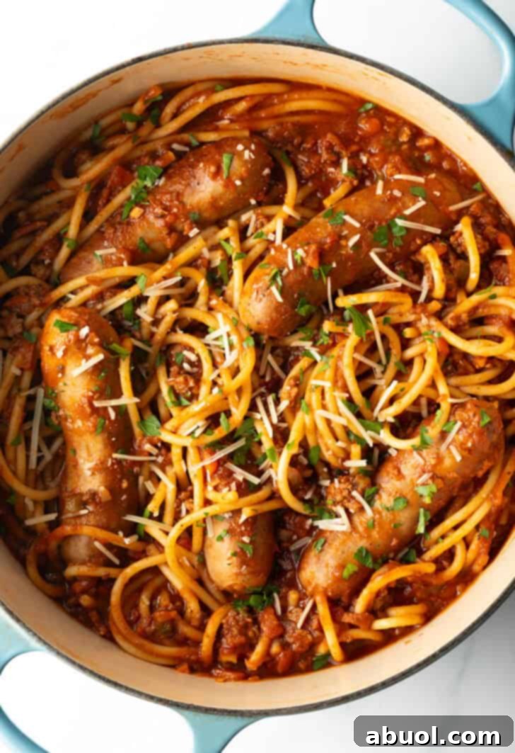 Top down one pot of spaghetti, sausage, and tomato sauce.