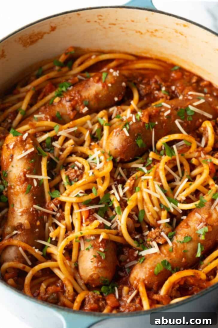 Top down one pot of spaghetti, sausage, and tomato sauce.