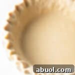 Close-up of unbaked pie dough with perfectly crimped edges in a pie plate, ready for the oven for a blind bake.