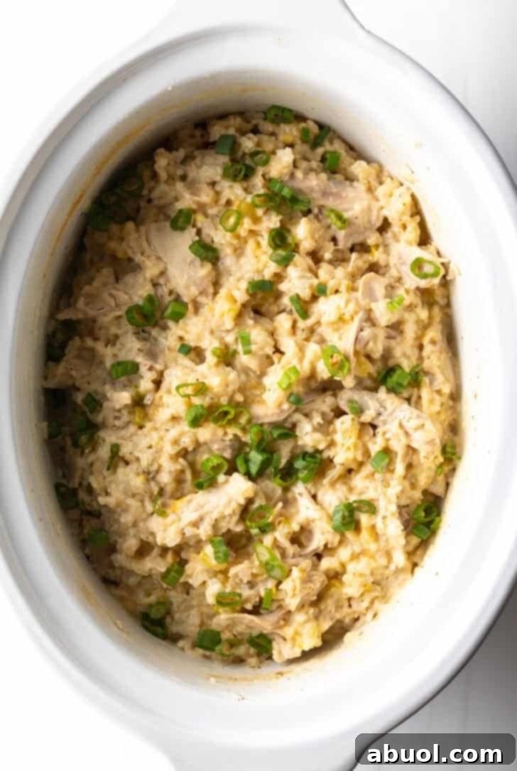 White crockpot with finished chicken and rice.