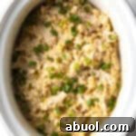 White crockpot with finished chicken and rice.