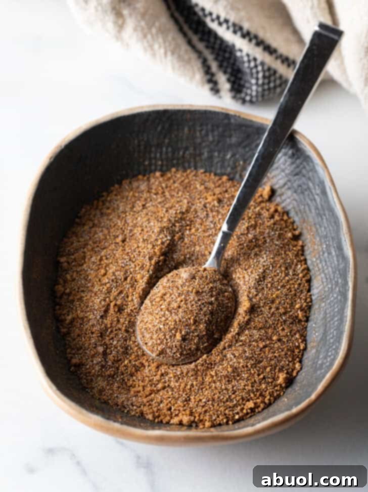 Blend of spices in an oval dish with metal spoon.
