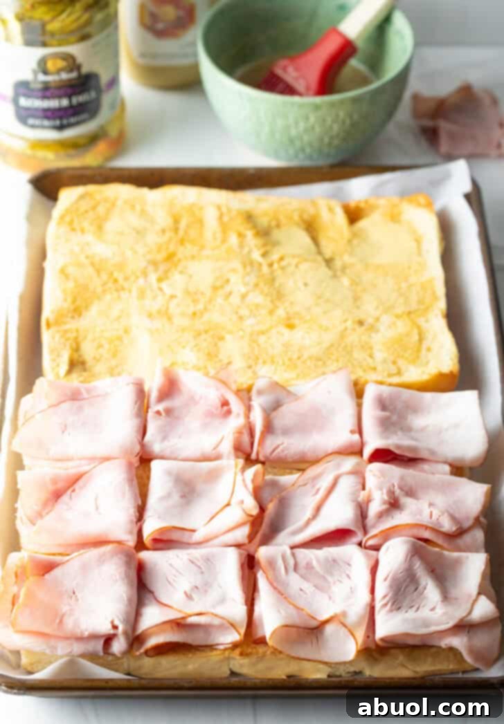 Sweet Hawaiian Bites 8 Assembling King's Hawaiian sliders with savory slices of deli ham layered over the cheese on the rolls.