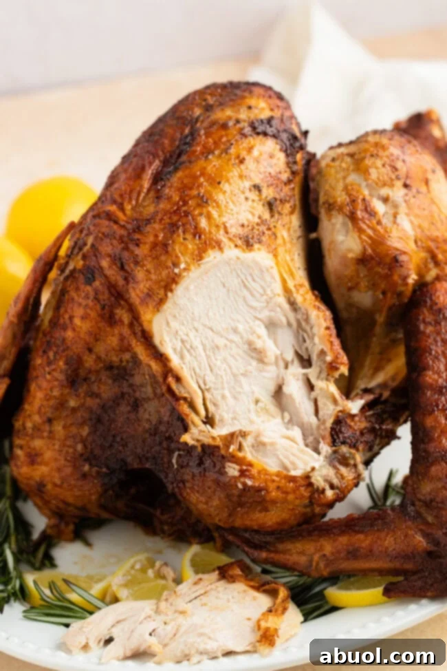 A carved deep-fried turkey breast slice on a platter, showcasing its moist texture and golden skin, ready to be served.