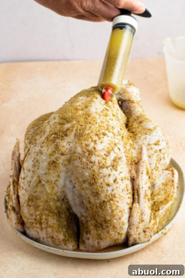 A close-up of a raw turkey breast being injected with marinade, showcasing the process of infusing flavor and moisture into the meat.