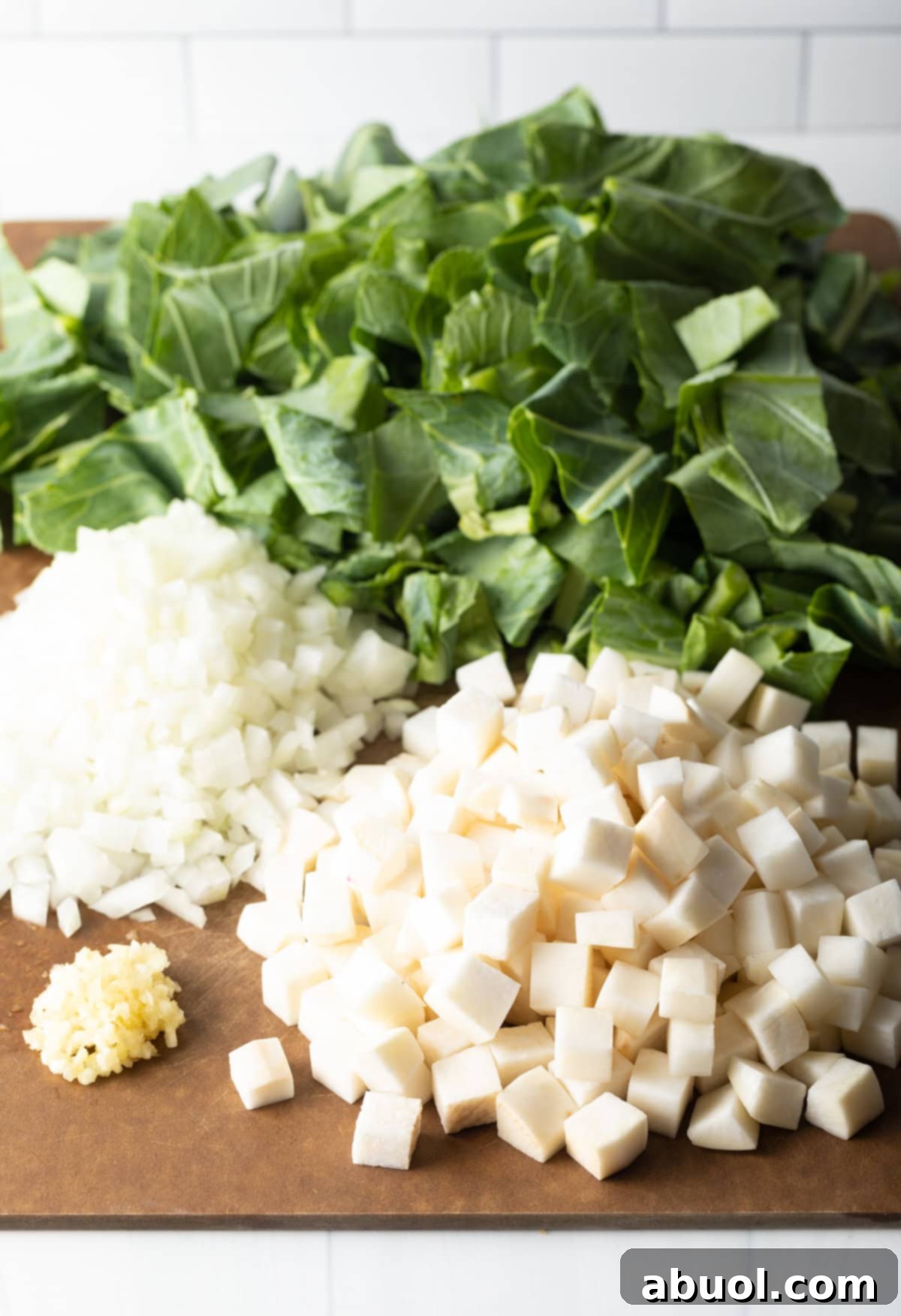 A rustic display of fresh ingredients laid out, including vibrant collard green bunches, whole turnips, aromatic garlic, and strips of bacon, ready for preparing Southern collard greens.