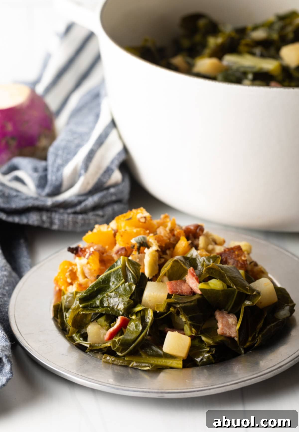 A beautifully plated serving of Southern stewed greens, garnished with crumbled bacon, alongside complementary side dishes.
