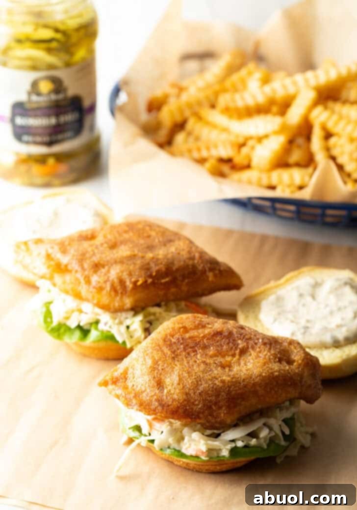 Adding coleslaw and fried fish to the bun.