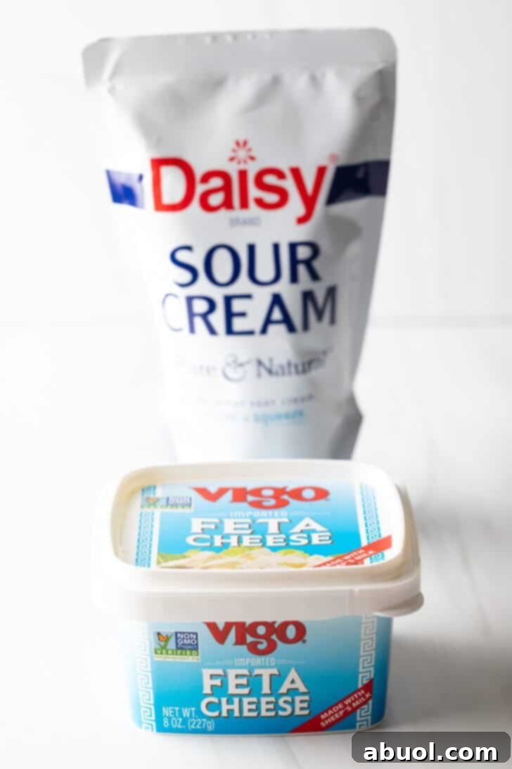 Container of sour cream and square container of feta cheese.