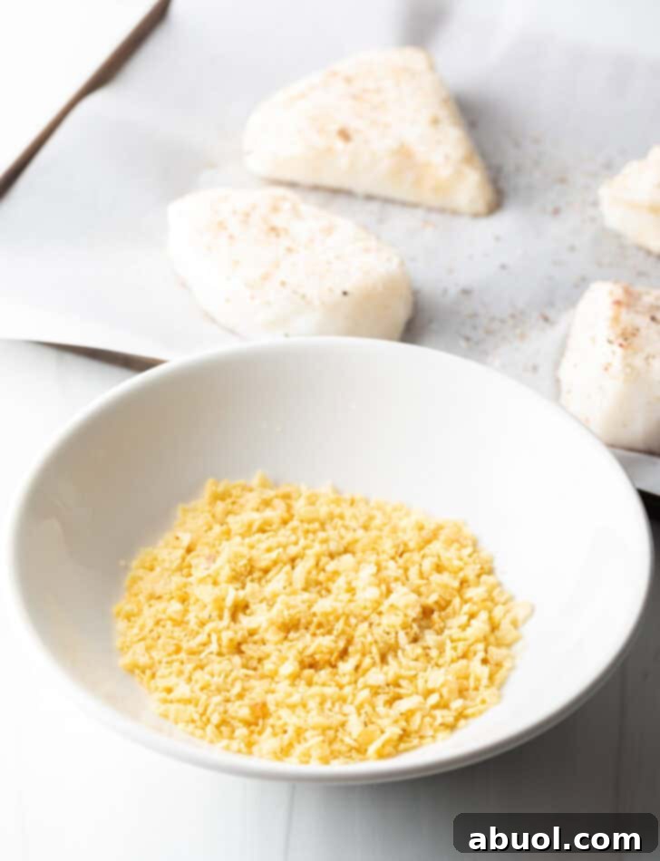 A close-up shot of potato chips being finely crushed in a food processor, creating perfect crumbs for the crispy fish coating.