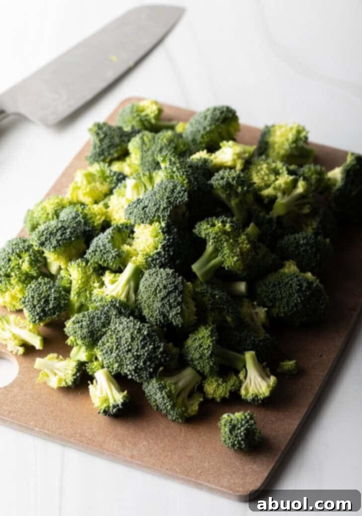 Chef cutting fresh broccoli into uniform florets for boiling.