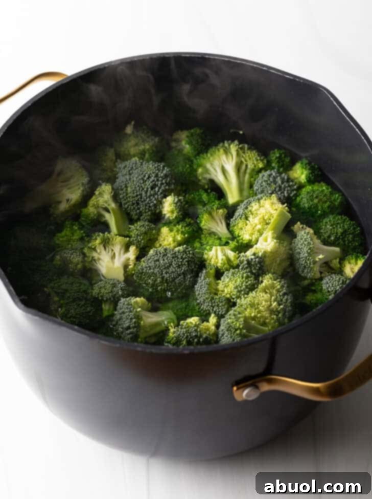Adding fresh broccoli florets into a large pot of vigorously boiling water.