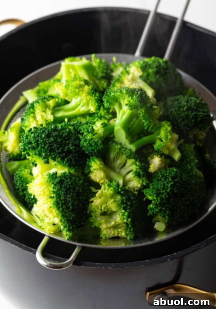 Draining cooked broccoli using a sieve or colander after boiling.