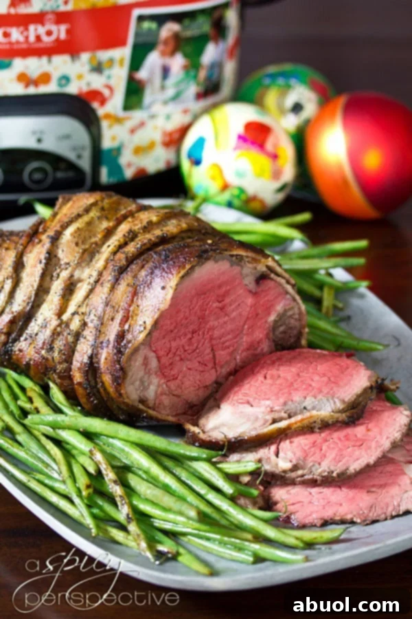 Crock Pot Beef Tenderloin with Balsamic Glaze - sliced on platter with fresh herbs
