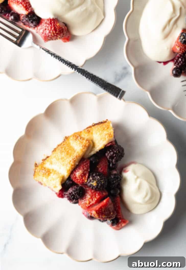 Another enticing view of a slice of crostata, artfully arranged on a white plate with a side of creamy ricotta, highlighting the vibrant berries and golden crust.
